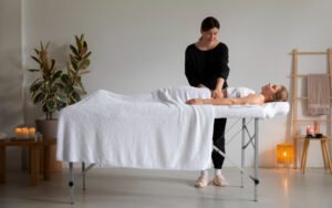 female therapist in Dubai provide massage services at home. Girl is laying on massage table.