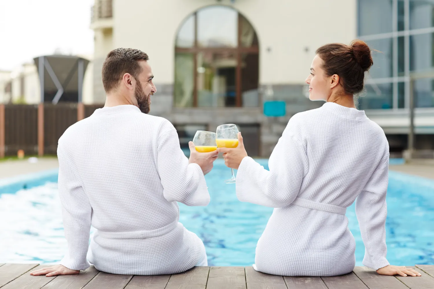 Couple relaxing beside a luxury pool during a premium spa and wellness experience in Dubai.